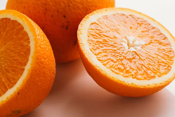 dilimlenmiş portakal yarısı ve bütün beyaz arka plan portre üzerinde