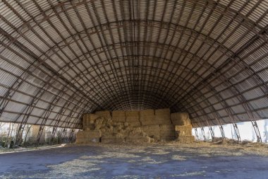 Saman veya saman depolamak için büyük bir hangar. Depo için koruma. Ahırda kuru saman..