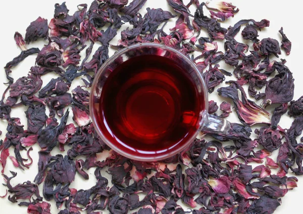 a cup of red tea on a background of Hibiscus.