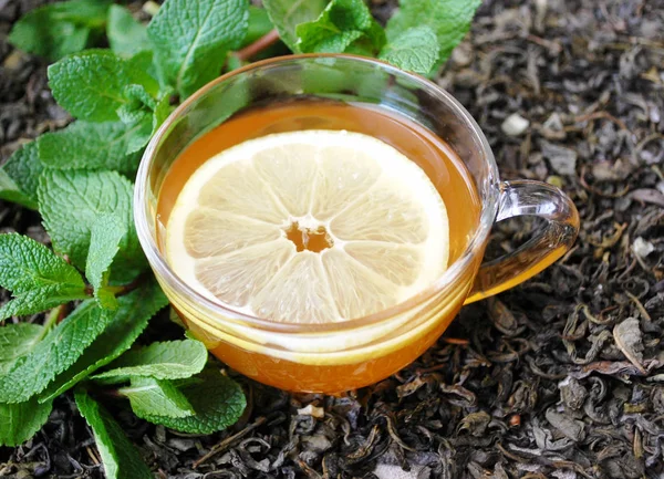 cup of green tea with lemon and mint leaves.