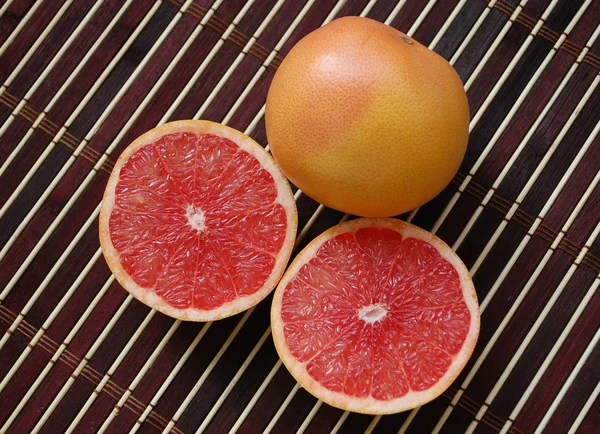 Красный грейпфрут, целые и два круглых ломтика . — стоковое фото