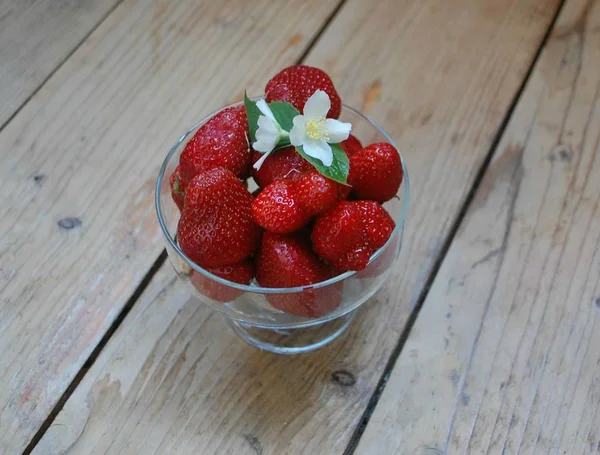 Glasskål med jordgubbar och jasmin blommor — Stockfoto