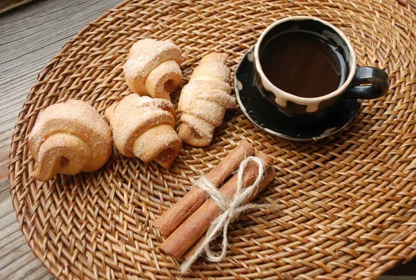 ブラック コーヒー クロワッサン Cinnamon 籐ナプキン 茶色背景の束の小さなカップ — ストック写真