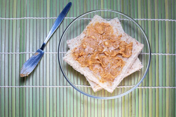 Une macro de beurre d'arachide étalée sur du pain de blé entier — Photo