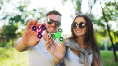 Genç çift parkta bir el spinner ile eğleniyor. Yaz yaşam tarzı kavramı