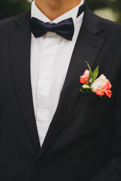 Primer plano de la elegancia manos masculinas. hombre vestido con traje azul y camisa blanca de pie sobre fondo verde de la naturaleza. novio en el día de la boda — Foto de Stock