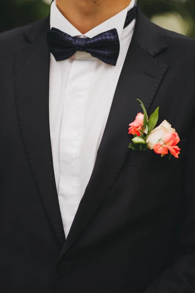 elegance erkek el yakın çekim. adam mavi takımı ve beyazlı duran yeşil doğa arka plan üzerinde giymiş. düğün günü damat