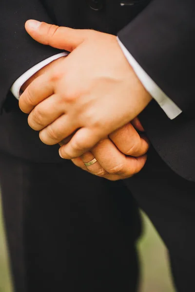 elegance erkek el yakın çekim. adam mavi takımı ve beyazlı duran yeşil doğa arka plan üzerinde giymiş. düğün günü damat
