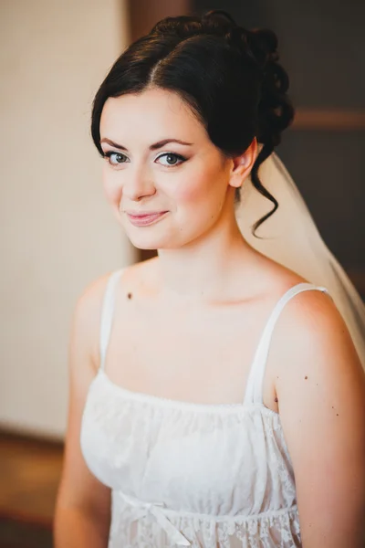 Retrato de novia hermosa. Mañana de la novia. Mañana de bodas. Maquillaje. chica con el pelo ondulado largo . — Foto de Stock