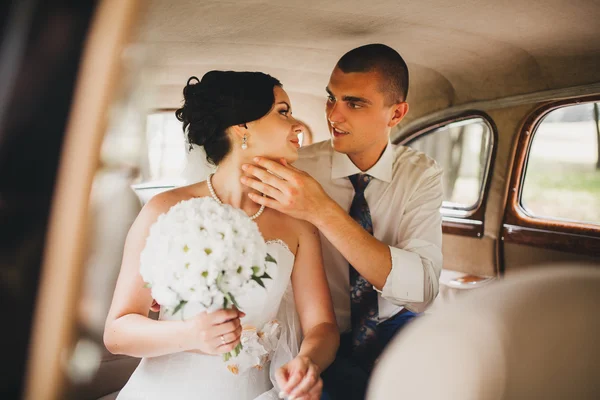 Bruid en bruidegom in een auto — Stockfoto