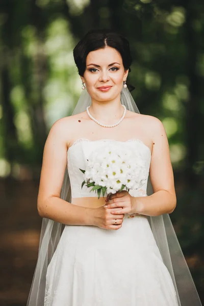 Bela noiva jovem com maquiagem de casamento e penteado — Fotografia de Stock