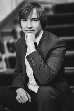 Muhteşem gülümseyen damat. Bir paketi kapalı pencere pervazına üzerinde oturan bir ilik ile yakışıklı adam