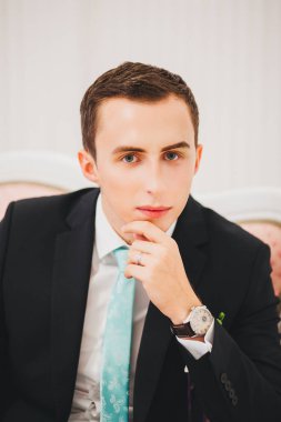 Muhteşem gülümseyen damat. Bir paketi kapalı pencere pervazına üzerinde oturan bir ilik ile yakışıklı adam