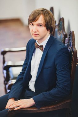 Muhteşem gülümseyen damat. Bir paketi kapalı pencere pervazına üzerinde oturan bir ilik ile yakışıklı adam