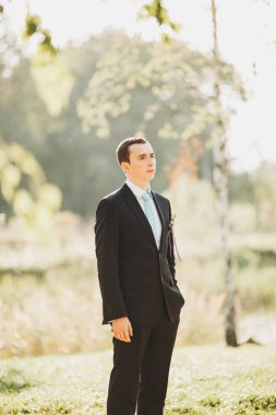 Muhteşem gülümseyen damat. Bir paketi kapalı pencere pervazına üzerinde oturan bir ilik ile yakışıklı adam