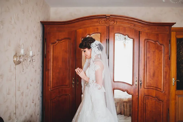 Jovem noiva em vestido de noiva segurando buquê — Fotografia de Stock