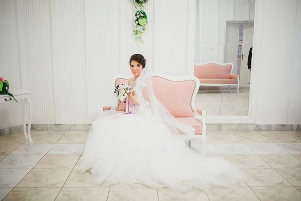 Молода наречена у весільній сукні тримає букет — стокове фото
