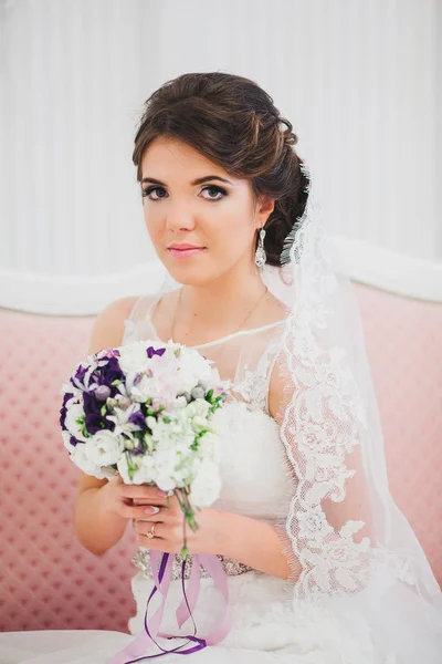 Молода наречена у весільній сукні тримає букет — стокове фото