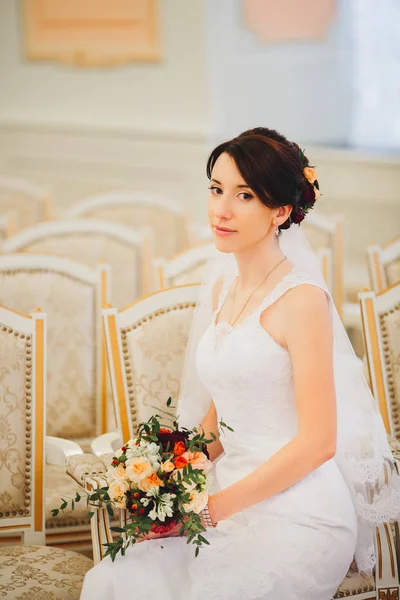 Junge Braut im Brautkleid mit Blumenstrauß — Stockfoto