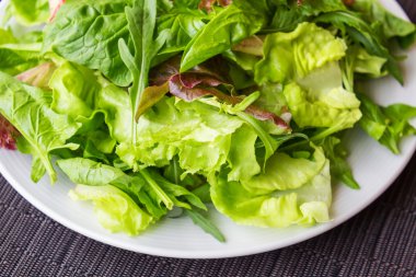 Taze bahar karışımı salata beyaz plaka üzerinde