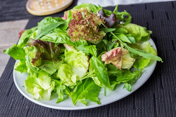 Свіжий весняний мікс салат на білій тарілці — стокове фото