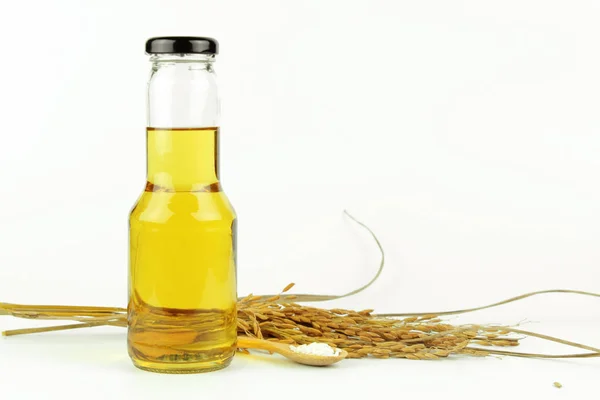 Rice bran oil in bottle glass and rice — Stock Photo, Image