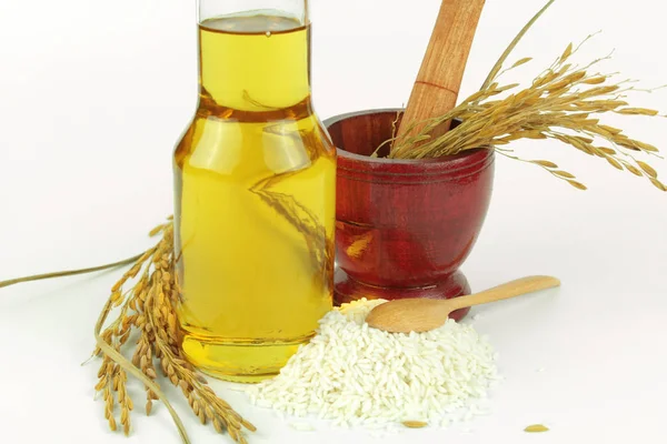 Aceite de salvado de arroz en botella de vidrio y arroz — Foto de Stock