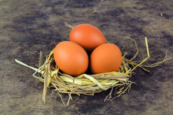 Brown eggs in nest hen eggs on wooden background