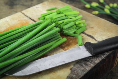 ahşap kesme tahtası üzerinde taze Frenk soğanı demet
