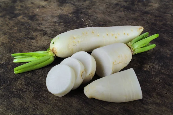 Čerstvé plátky bílé ředkvičky na dřevěné pozadí, zdravý zeleninový — Stock fotografie