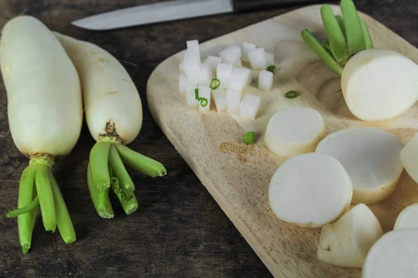 Свіжі скибочки білої редьки на дерев'яному фоні, здоровий вегетаріанський — стокове фото