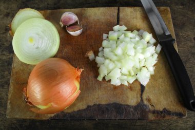 Ahşap kesme tahtası üzerinde tüm ve dilimlenmiş soğan