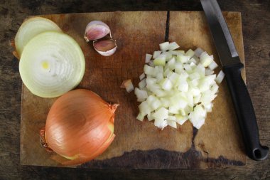 Ahşap kesme tahtası üzerinde tüm ve dilimlenmiş soğan