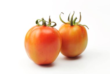 Beyaz arka planda yeşil yapraklı taze domatesler.