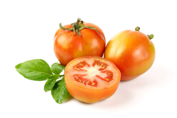 Tomates frescos con hojas verdes aisladas sobre fondo blanco — Foto de Stock