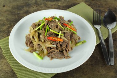 soğan ve taze soğan ile kızartılmış sığır eti ilave edin