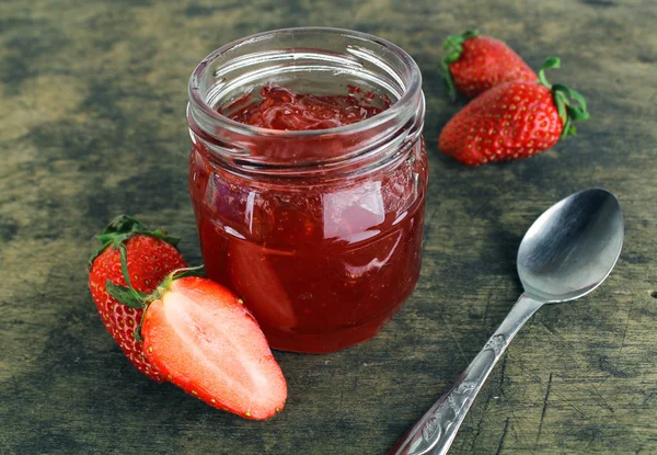 Verse aardbeien jam in glazen fles met muntblad — Stockfoto