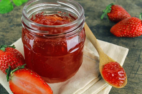 Verse aardbeien jam in glazen fles met muntblad — Stockfoto