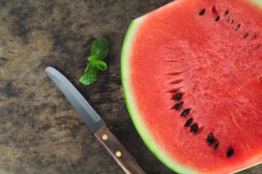 Kırmızı karpuz bir bütün ve nane yaprağıyla dilimlenmiş.