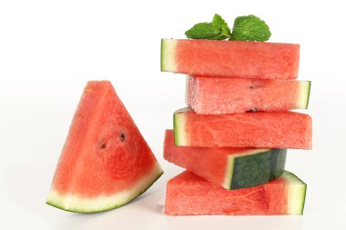 Kırmızı karpuz bir bütün ve nane yaprağıyla dilimlenmiş.