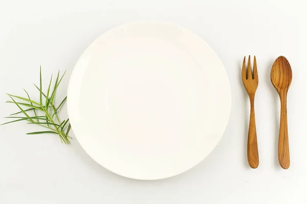 Weißer Teller auf weißem Hintergrund Dekoration mit Löffel und Gabel — Stockfoto