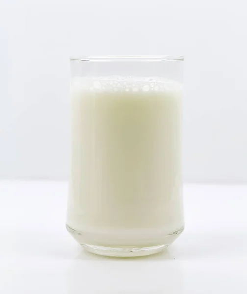 Una botella de leche y un vaso de leche sobre una mesa de madera sobre un fondo —  Fotos de Stock