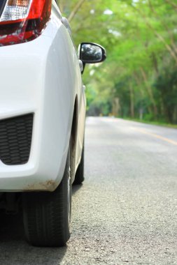 Beyaz araba asfalt yolda otopark önü