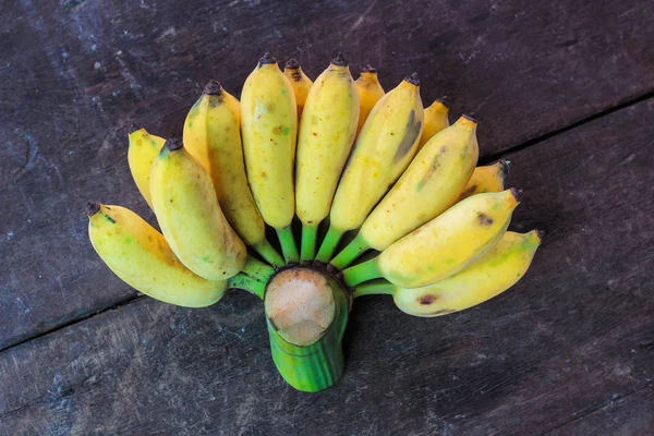 Świeży żółty dojrzałych bananów na brązowym tle — Zdjęcie stockowe