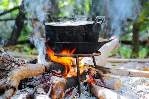 Tűzifa égető a kandalló mellett, a régi fekete főzés bankot és a füst — Stock Fotó