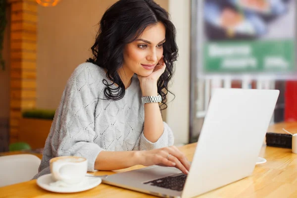laptop ile kafede oturan kadın