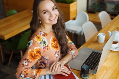 dizüstü gülümseyen oturan genç kadın