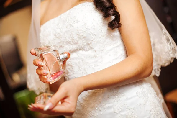 Bride Holds Perfume in Hand and Splashes on Wrist