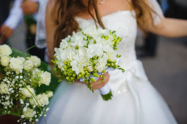 Novia en vestido sostiene ramo de novia con Freesia — Foto de Stock