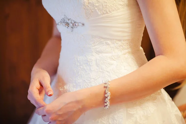Elegante bruids witte jurk en jonge vrouwelijke handen — Stockfoto